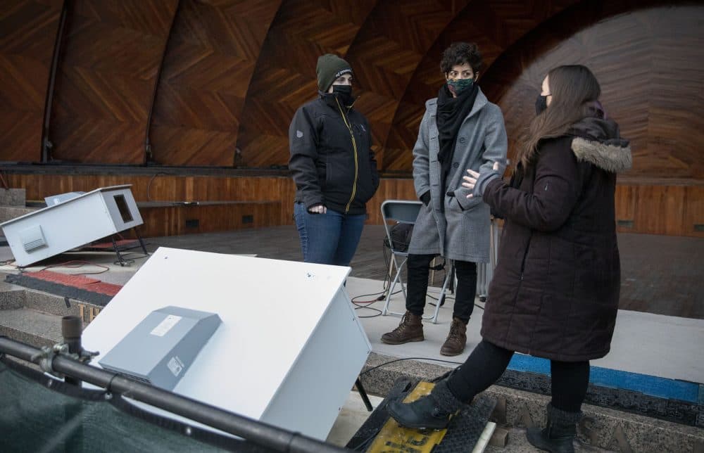 Project manager Jane Long, technical director Pamela Hersch and artist Maria Finkelmeier stand by one of the projector boxes that will light up the Hatch Shell for &quot;Hatched: Breaking through the Silence.&quot; (Robin Lubbock/WBUR)