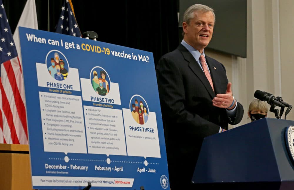 Gov. Charlie Baker speaks to the media on Jan. 25 in front of the updated vaccination phase chart. (Matt Stone/Boston Herald, Pool)