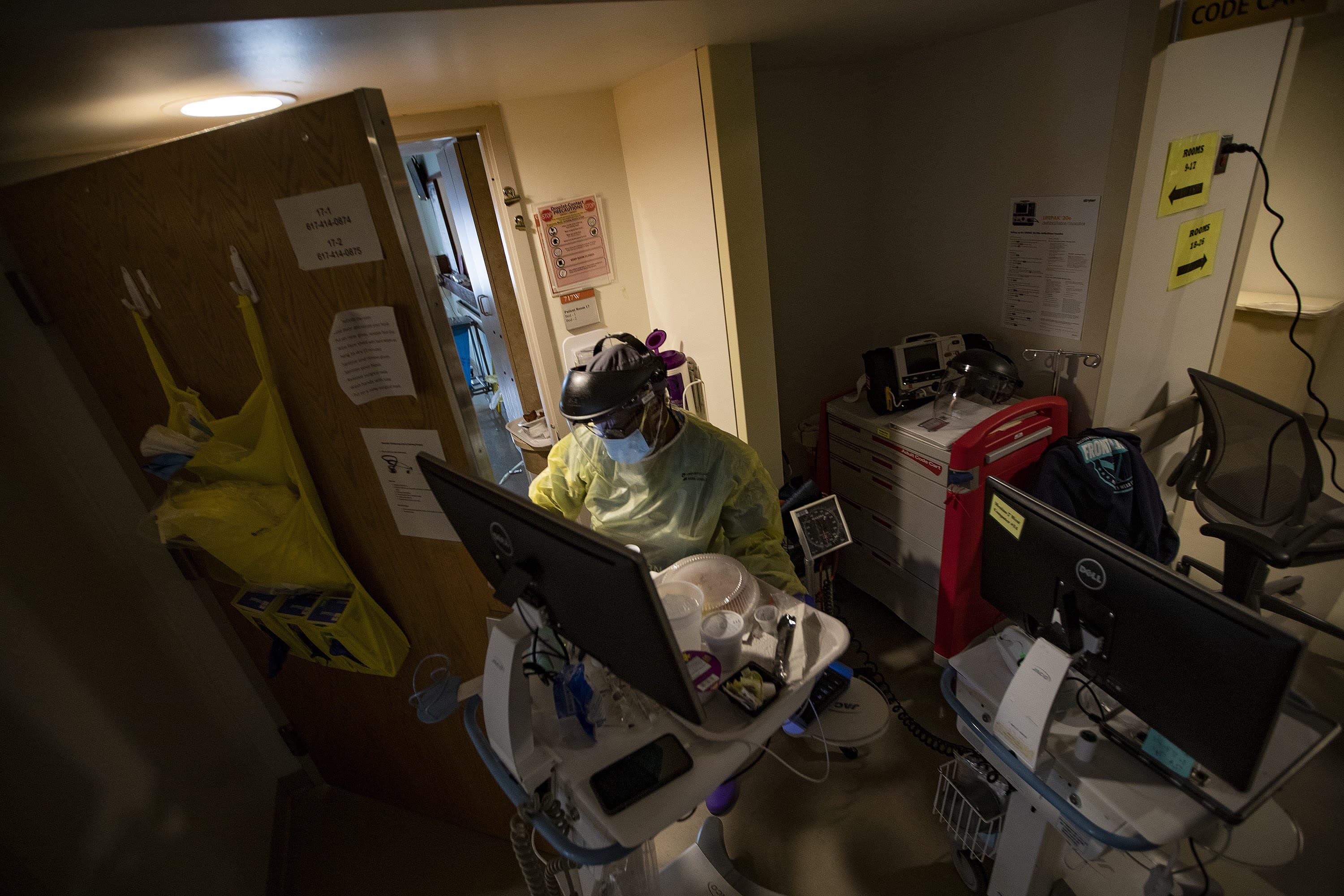 Stephenson prepares to enter a room of a COVID-19 patient with supplies. (Jesse Costa/WBUR)