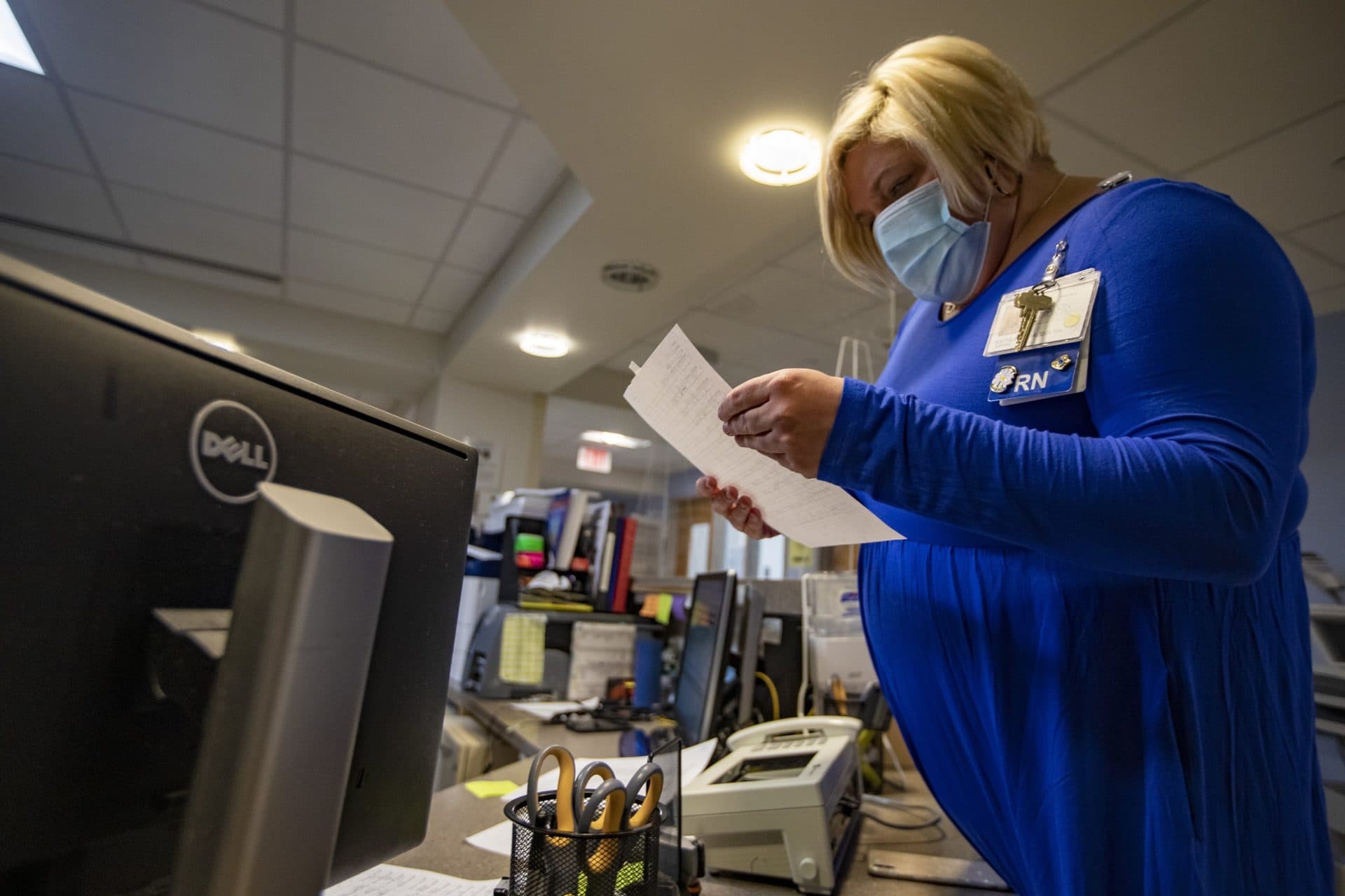Nurse manager Kate Baudin looks at a list of patients staying in the special contagious disease unit at BMC. (Jesse Costa/WBUR)