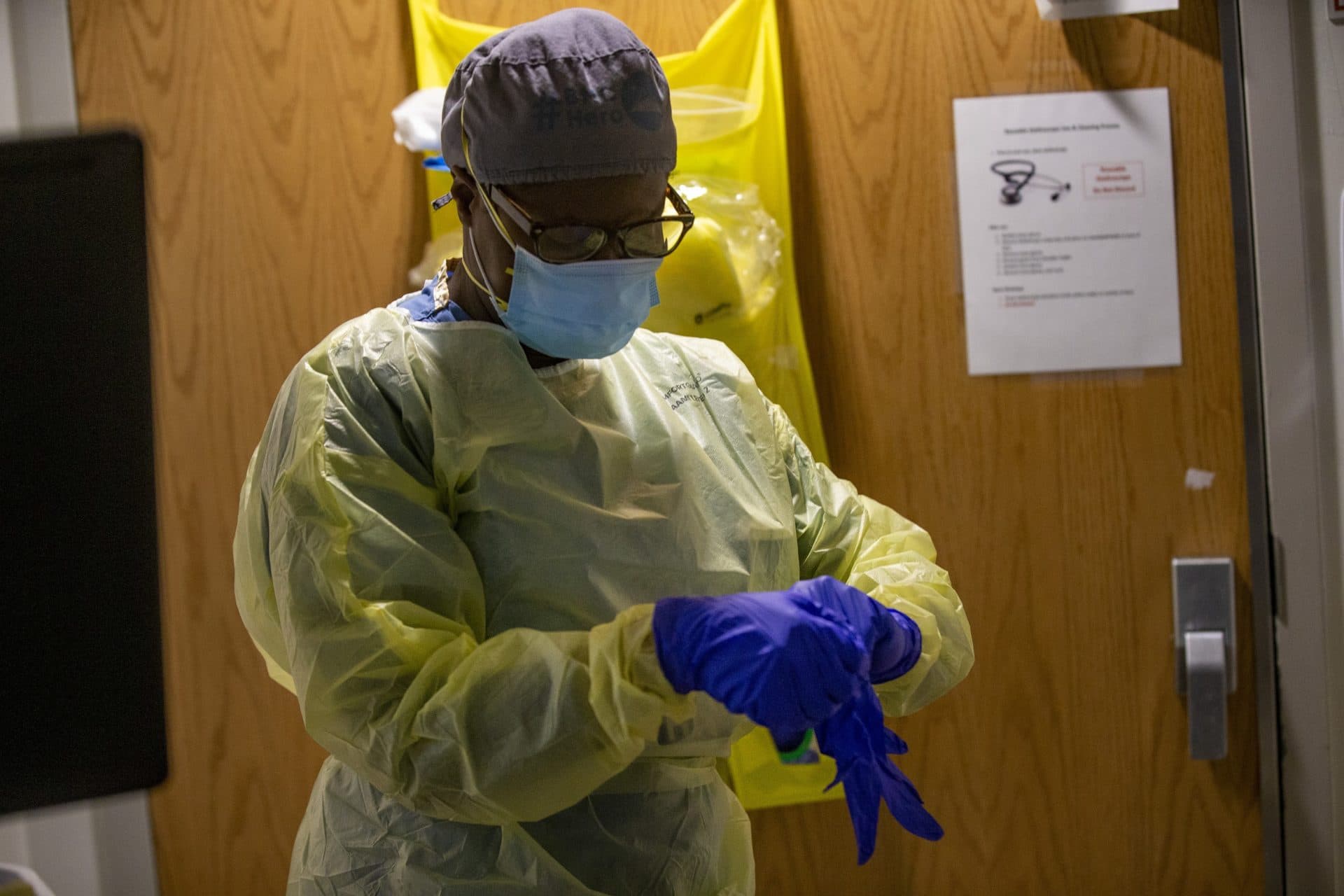 Boston Medical Center registered nurse Ellen Stephenson puts on personal protective equipment as she prepares to enter a room of a COVID-19 patient. (Jesse Costa/WBUR)