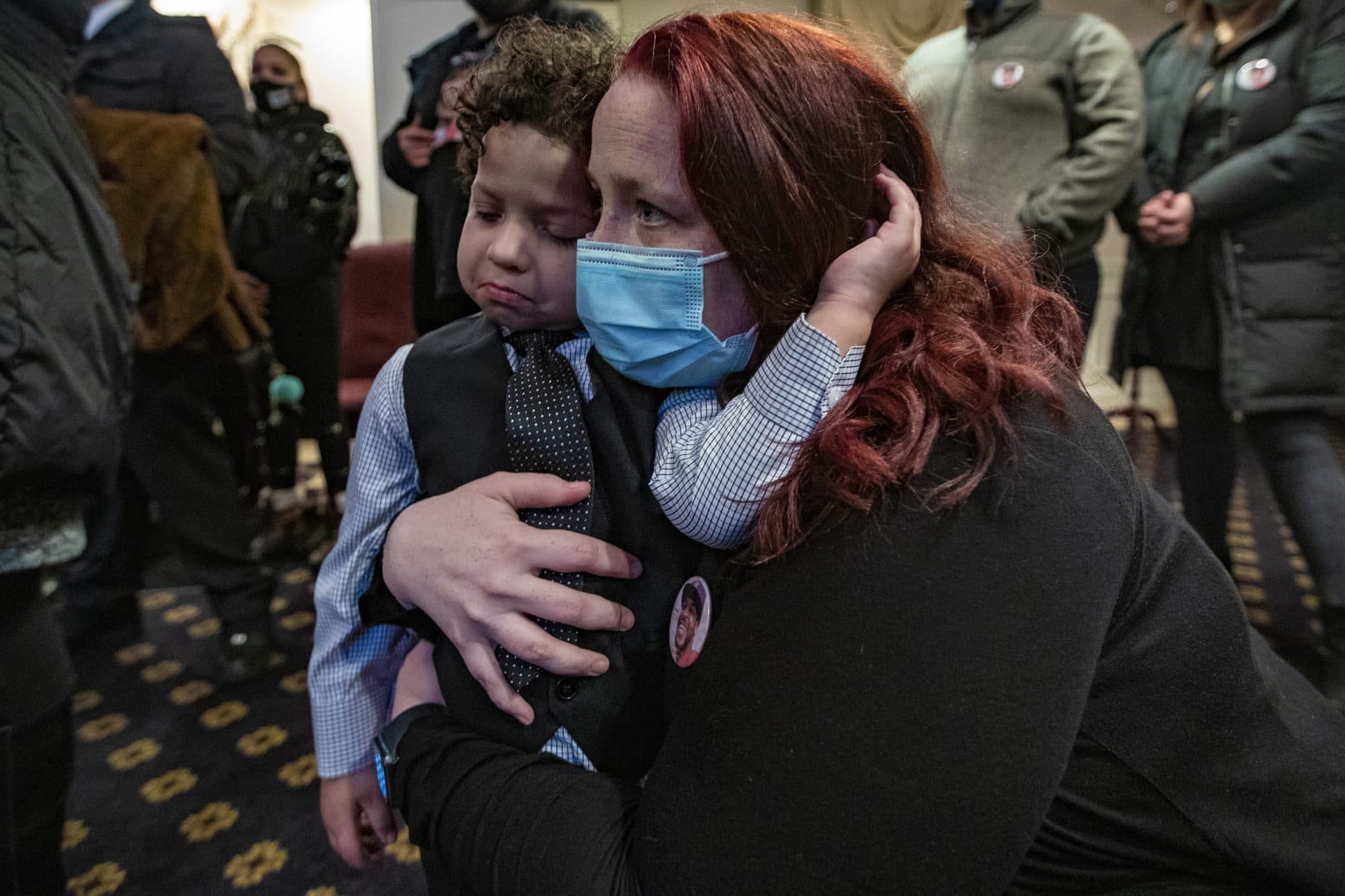 Henry Tapia's girlfriend Courtney Morton holds their 3-year-old son Eli during his funeral service. (Jesse Costa/WBUR)