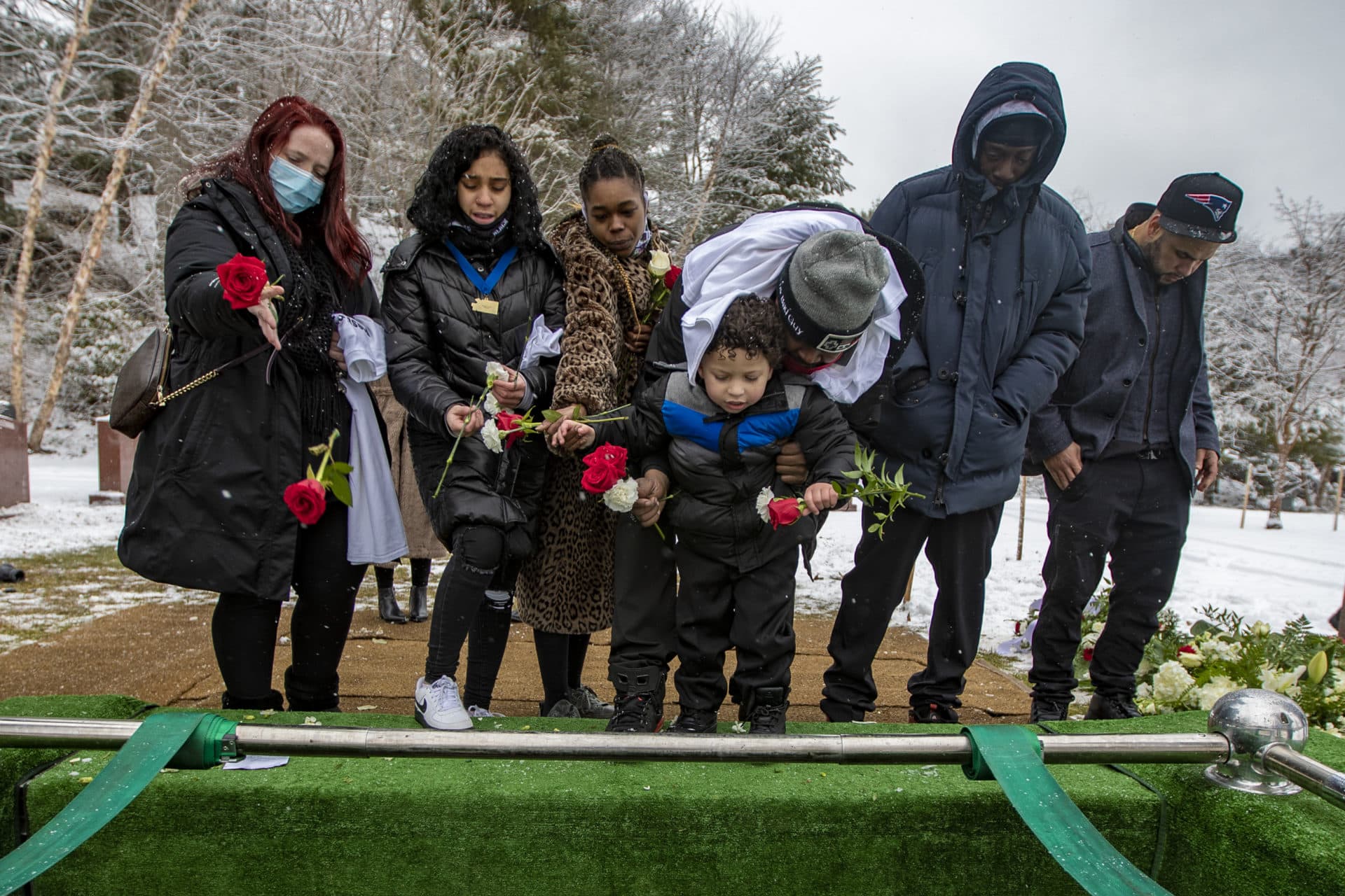 Henry Tapia's family leaves flowers in his grave. (Jesse Costa/WBUR)