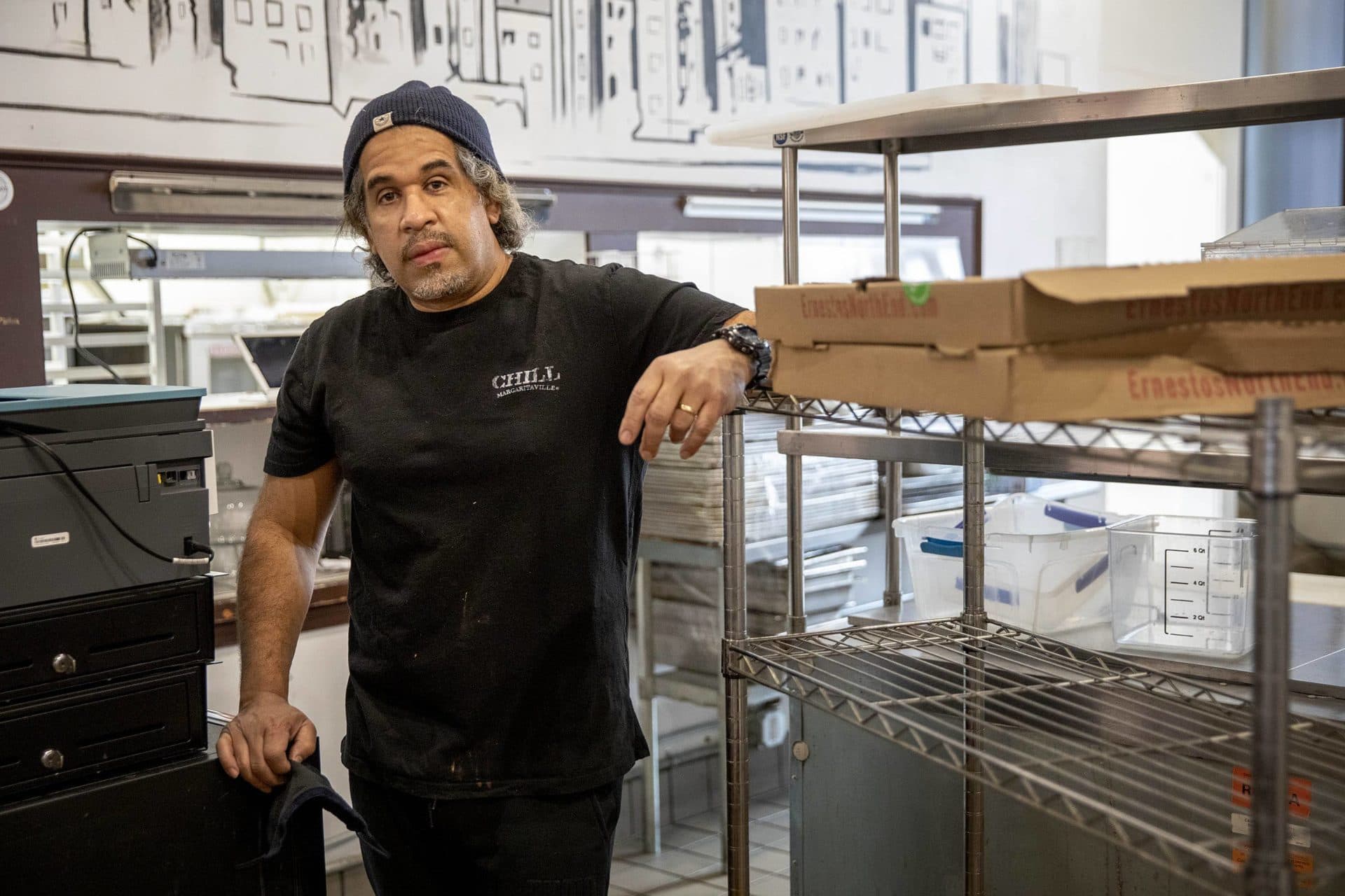 Jayme Valdez, co-owner of The Kitchen Cafe, stands surrounded by kitchen equipment as he closes down the business. (Robin Lubbock/WBUR)