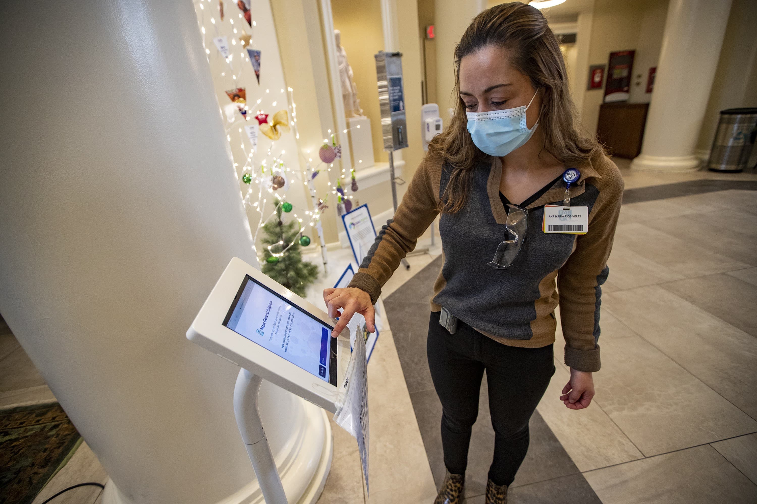 Interpreter Ana Maria Rios-Velez demonstrates the screening app at the Brigham and Women's Hospital front entrance. (Jesse Costa/WBUR)