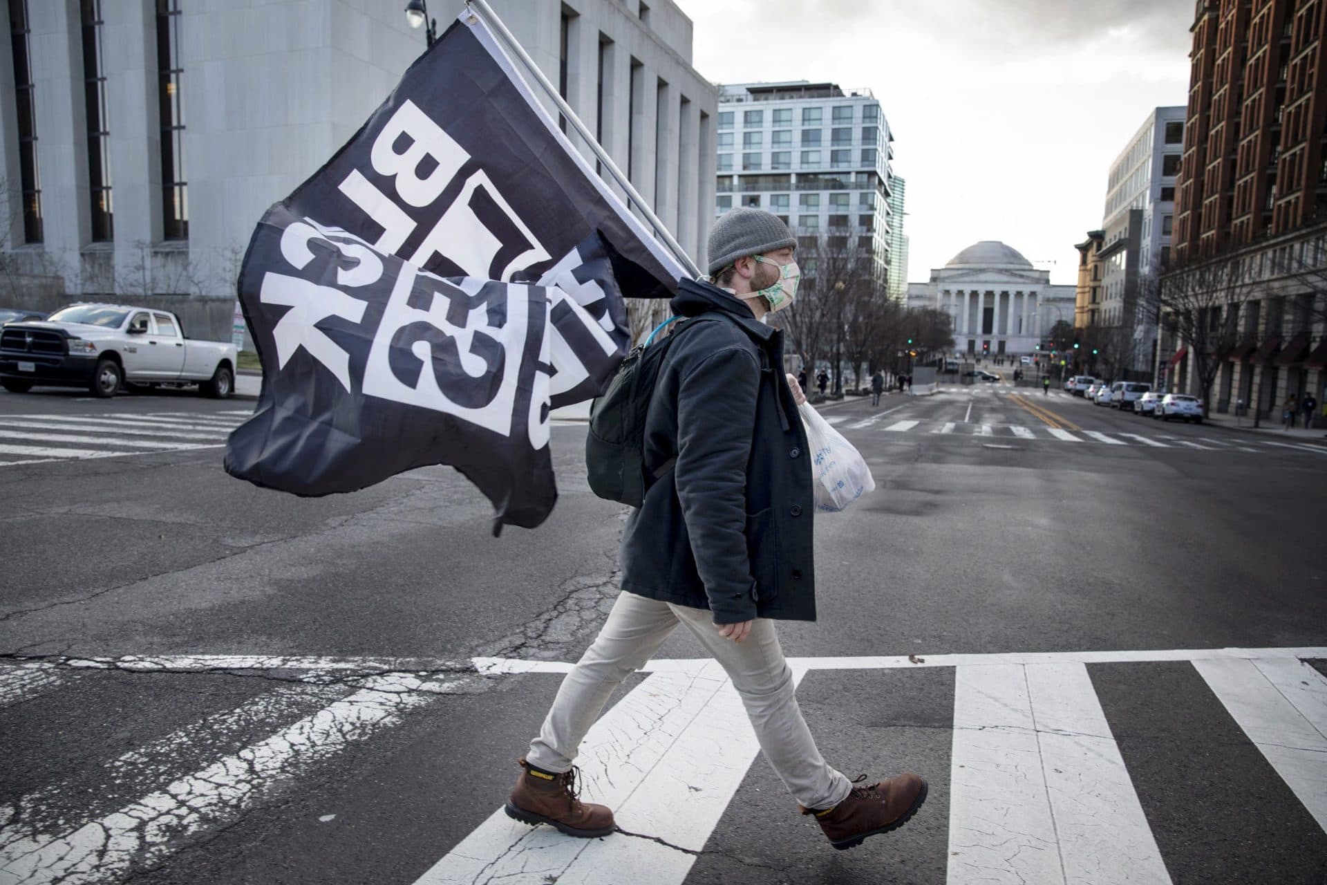Jack Curtz, who lives in Boston, walks through downtown D.C. holding a Black Lives Matter flag. (Tyrone Turner/WAMU)