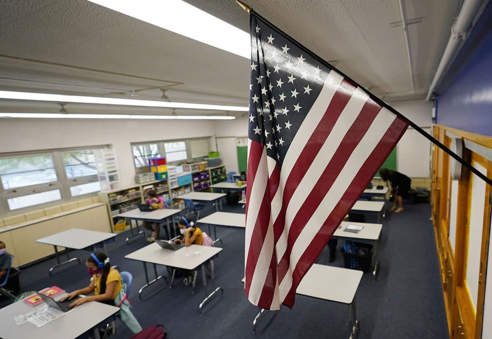 A U.S. flag hangs in a classroom as students work on laptops in Newlon Elementary School in Denver, Colorado. (David Zalubowski/AP)