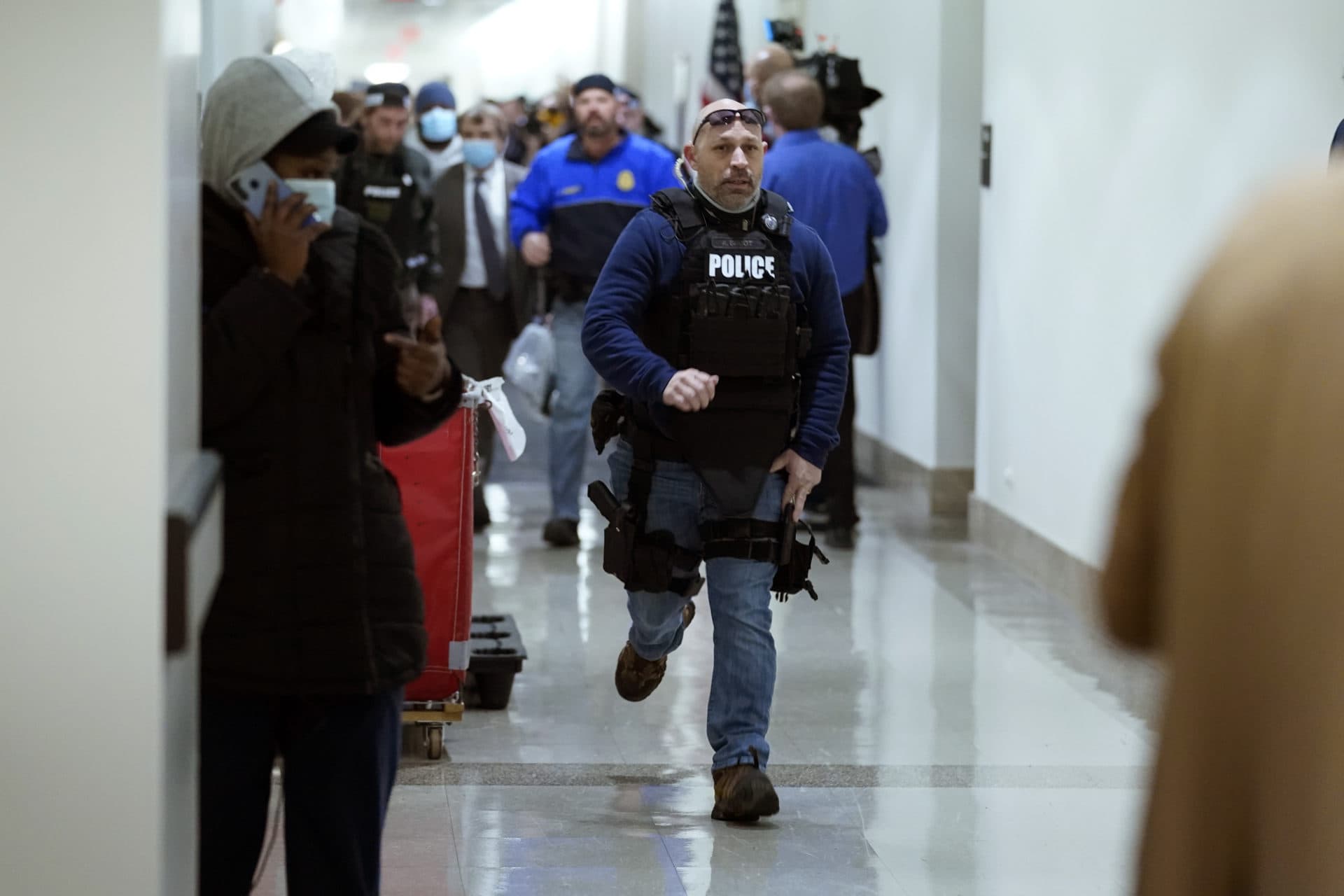 People run in the halls as protesters try to break into the House Chamber. (Andrew Harnik/AP)