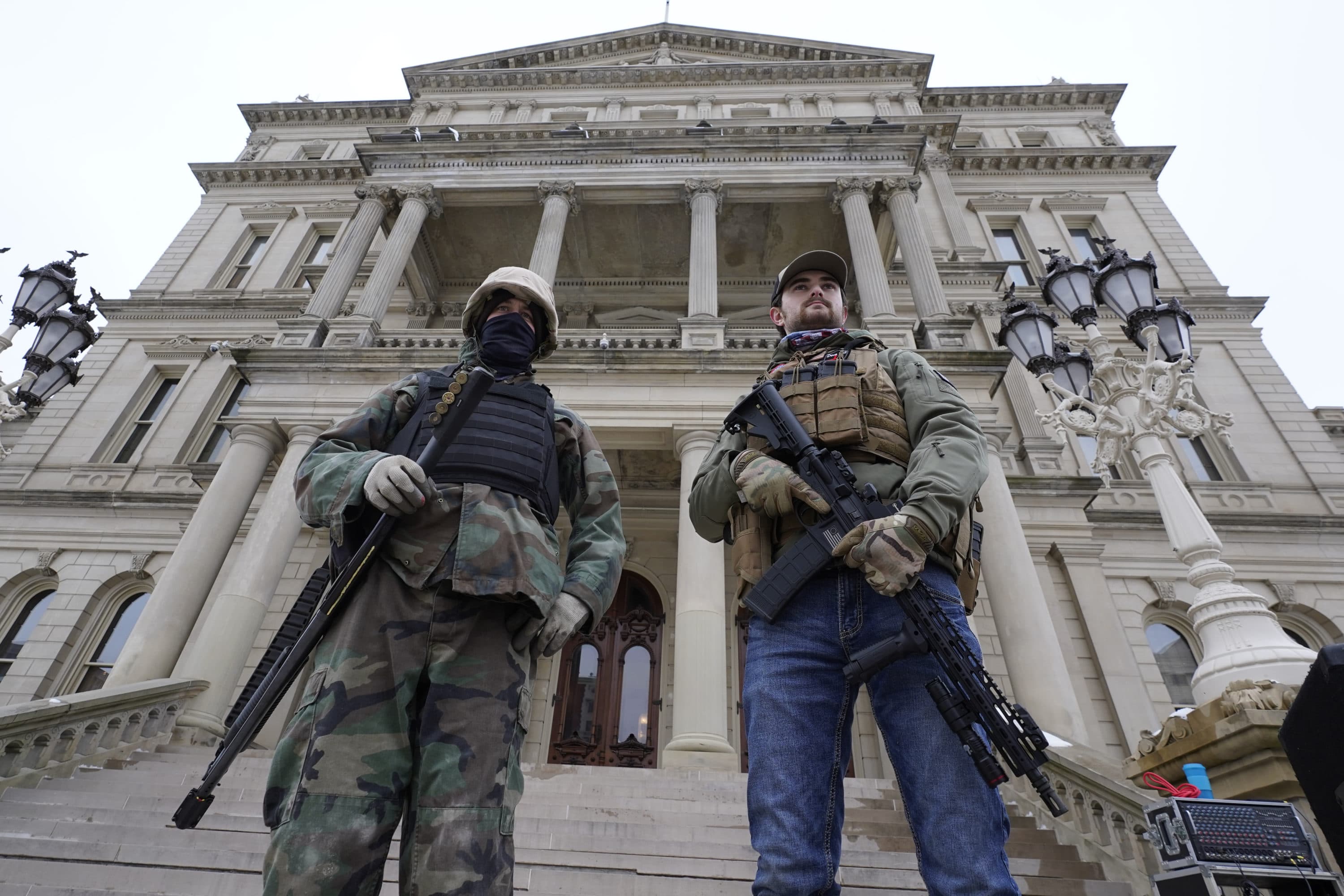 Armed men stand on the steps at the State Capitol after a rally in support of President Trump in Lansing, Michigan, on Jan. 6, 2021. (Paul Sancya/AP)