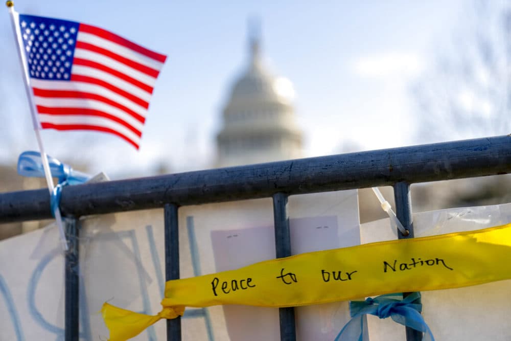 A ribbon reading &quot;Peace to Our Nation&quot; is visible at a memorial for Capitol Police Officer Brian D. Sicknick near the Capitol Building on Capitol Hill in Washington, Thursday, Jan. 14, 2021. (AP Photo/Andrew Harnik)