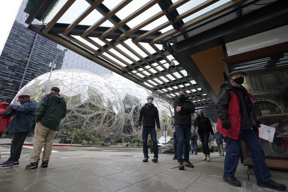 People wait in line near the Amazon Spheres as they wait to check in to receive the first of two doses of the Pfizer vaccine for COVID-19 at a one-day vaccination clinic set up in an Amazon.com facility in Seattle and operated by Virginia Mason Franciscan Health on Jan. 24, 2021. (Ted S. Warren/AP File)