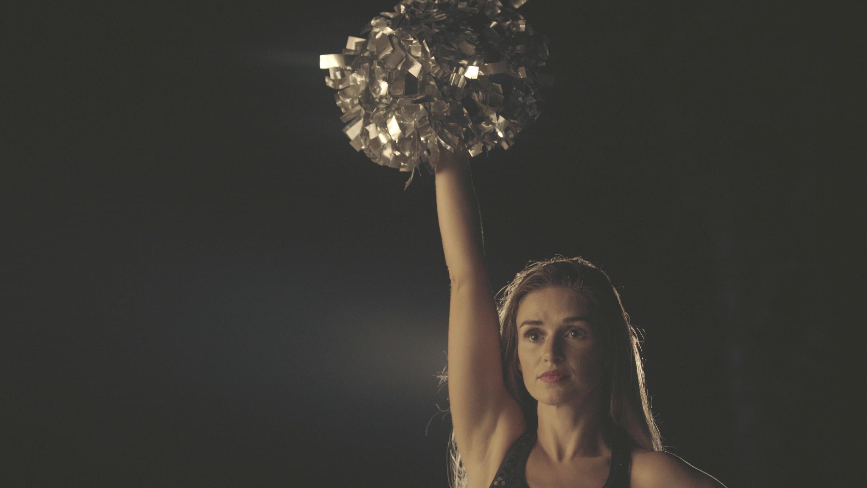 Lacy Thibodeaux standing with pom poms in the air. (Photo by Yu Gu)
