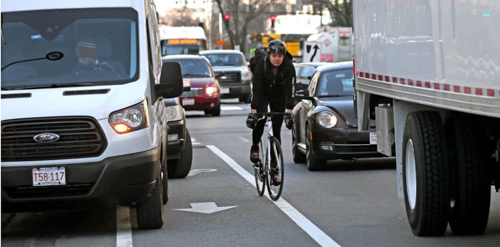 Vehicles block part of a bike lane on Main Street in Cambridge, MA, causing a bicyclist to compete with traffic, on Jan. 25, 2019. (David L. Ryan/The Boston Globe via Getty Images)
