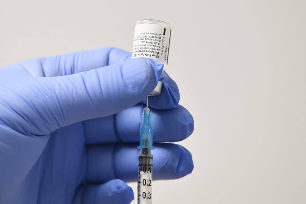 A needle and a phial of Pfizer-BioNTech COVID-19 vaccine are used to prepare a dose. (Justin Tallis/AFP via Getty Images)