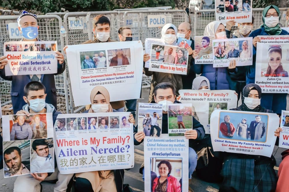Members of the Muslim Uighur minority hold placards as they demonstrate in front of the Chinese consulate on December 30, 2020, in Istanbul, to ask for news of their relatives. (Bulent Kilic/AFP via Getty Images)