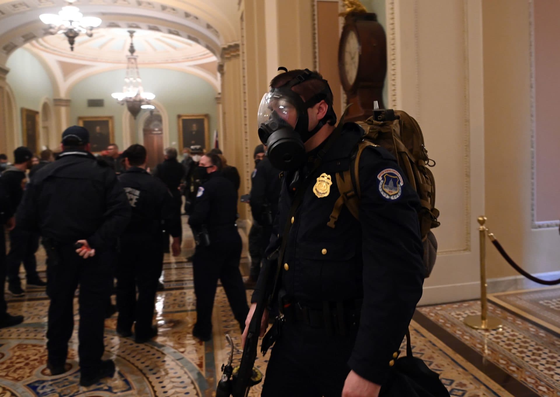 A U.S. Capitol police officer wears a gas mask as supporters of US President Donald Trump enter the Capitol on Jan. 6, 2021, in Washington, D.C. (Saul Loeb/AFP via Getty Images) 