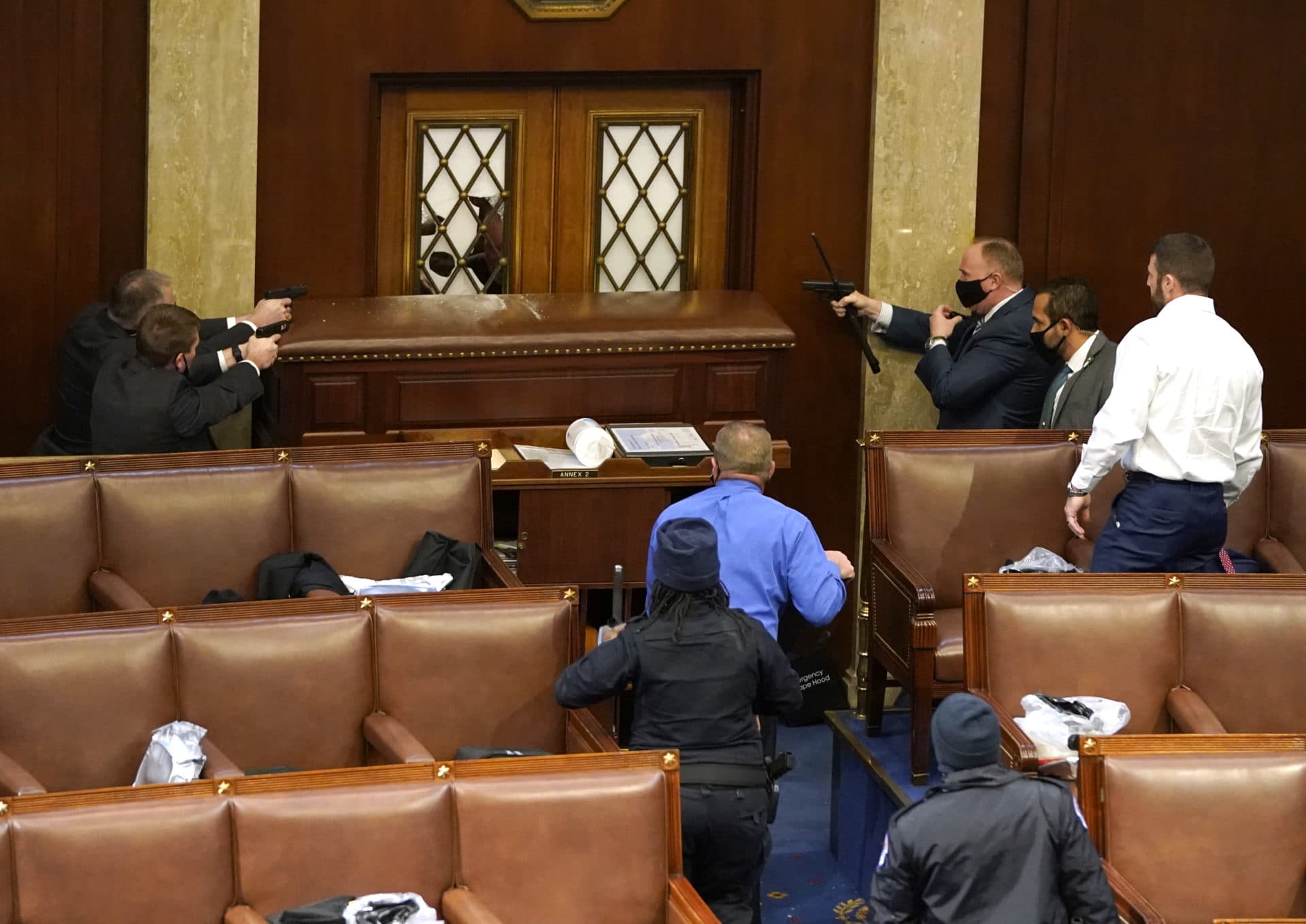 Capitol police officers point their guns at a door that was vandalized in the House Chamber during a joint session of Congress on Wednesday. (Drew Angerer/Getty Images)