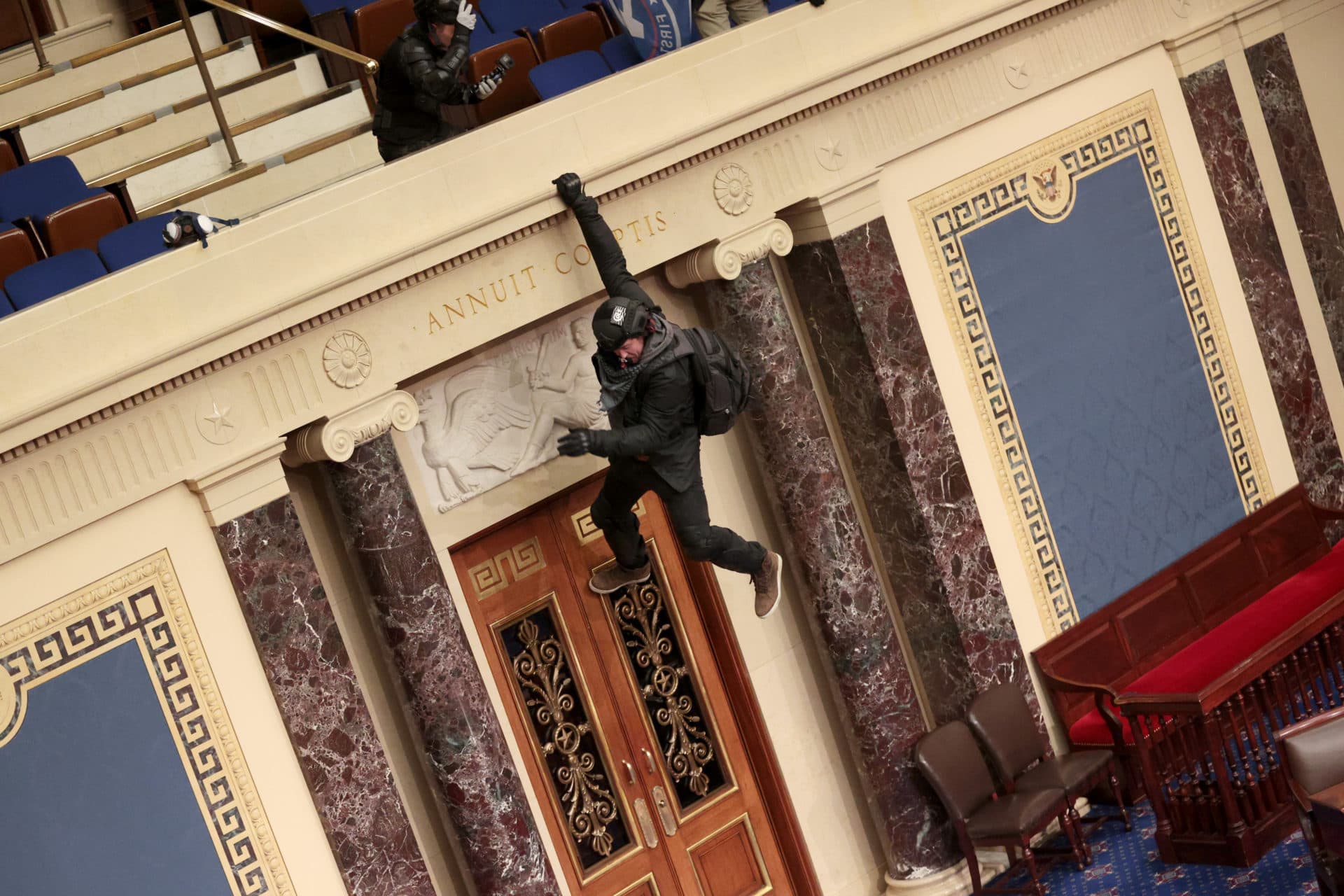 A protester is seen hanging from the balcony in the Senate Chamber. (Win McNamee/Getty Images)