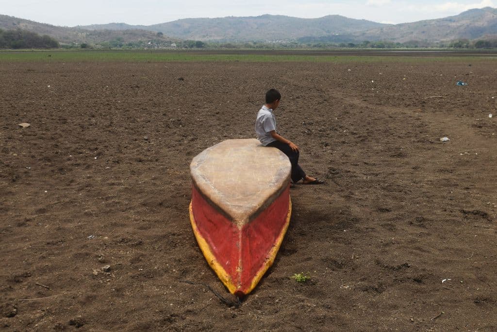 A boy sits on an abandoned boat on what is left of Lake Atescatempa, which has dried up due to drought and high temperatures, in Atescatempa, 174 km southeast of Guatemala City, on May 5, 2017. - ( Marvin Recino/AFP via Getty Images)