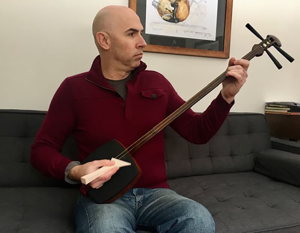 Composer Eric Shimelonis playing the shamisen. (courtesy Rebecca Sheir)