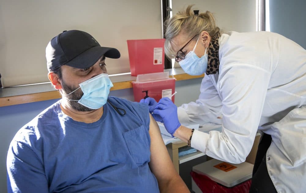 Volunteer nurse Cheryl Duval gives David Confer his COVID-19 vaccination. (Robin Lubbock/WBUR)