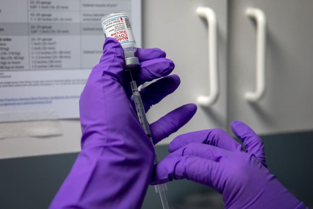 A volunteer prepares a COVID vaccination shot. (Robin Lubbock/WBUR)