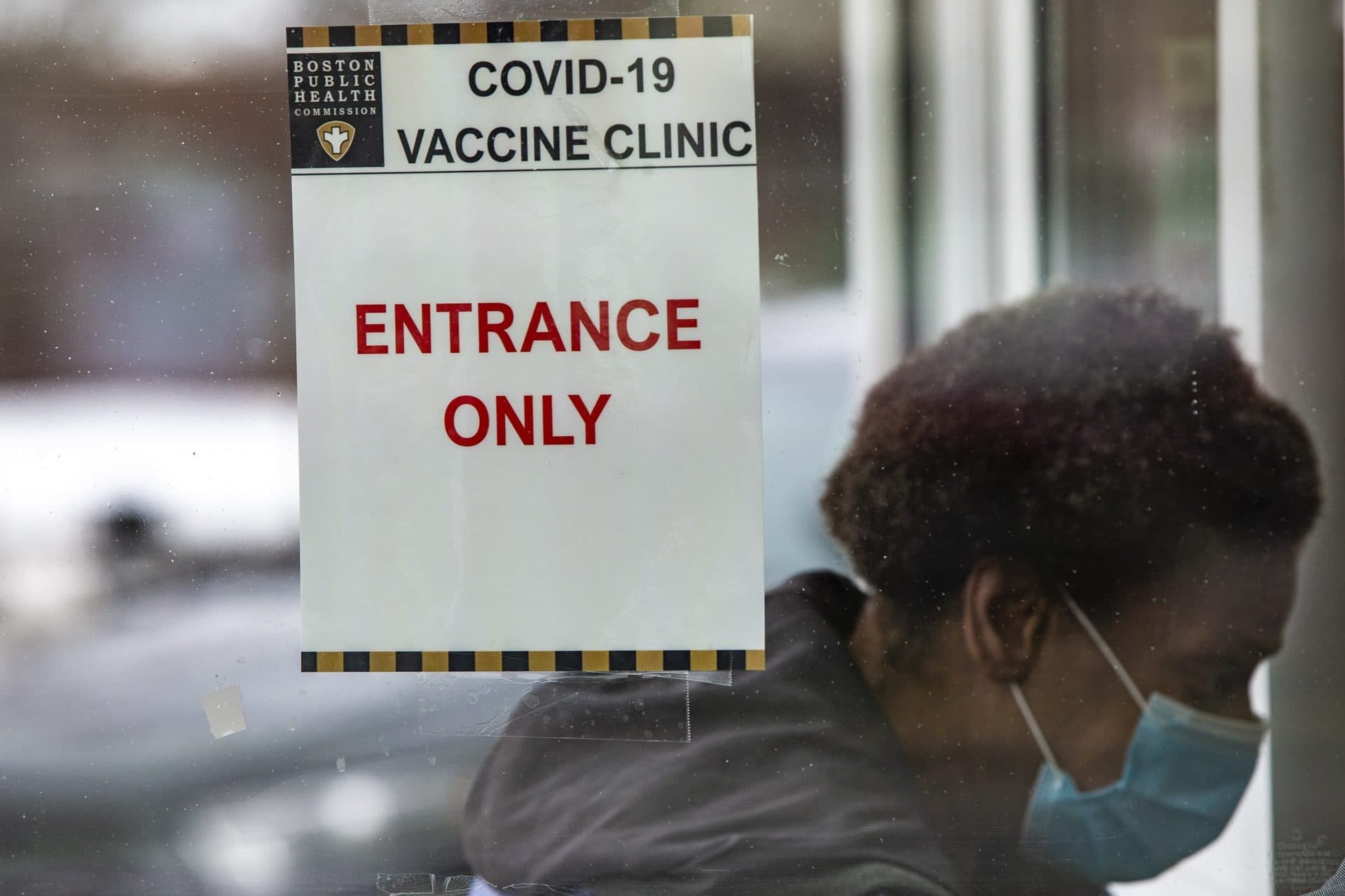 A woman walks through the front entrance of the Reggie Lewis Center to be immunized with COVID-19 vaccine. (Jesse Costa/WBUR)