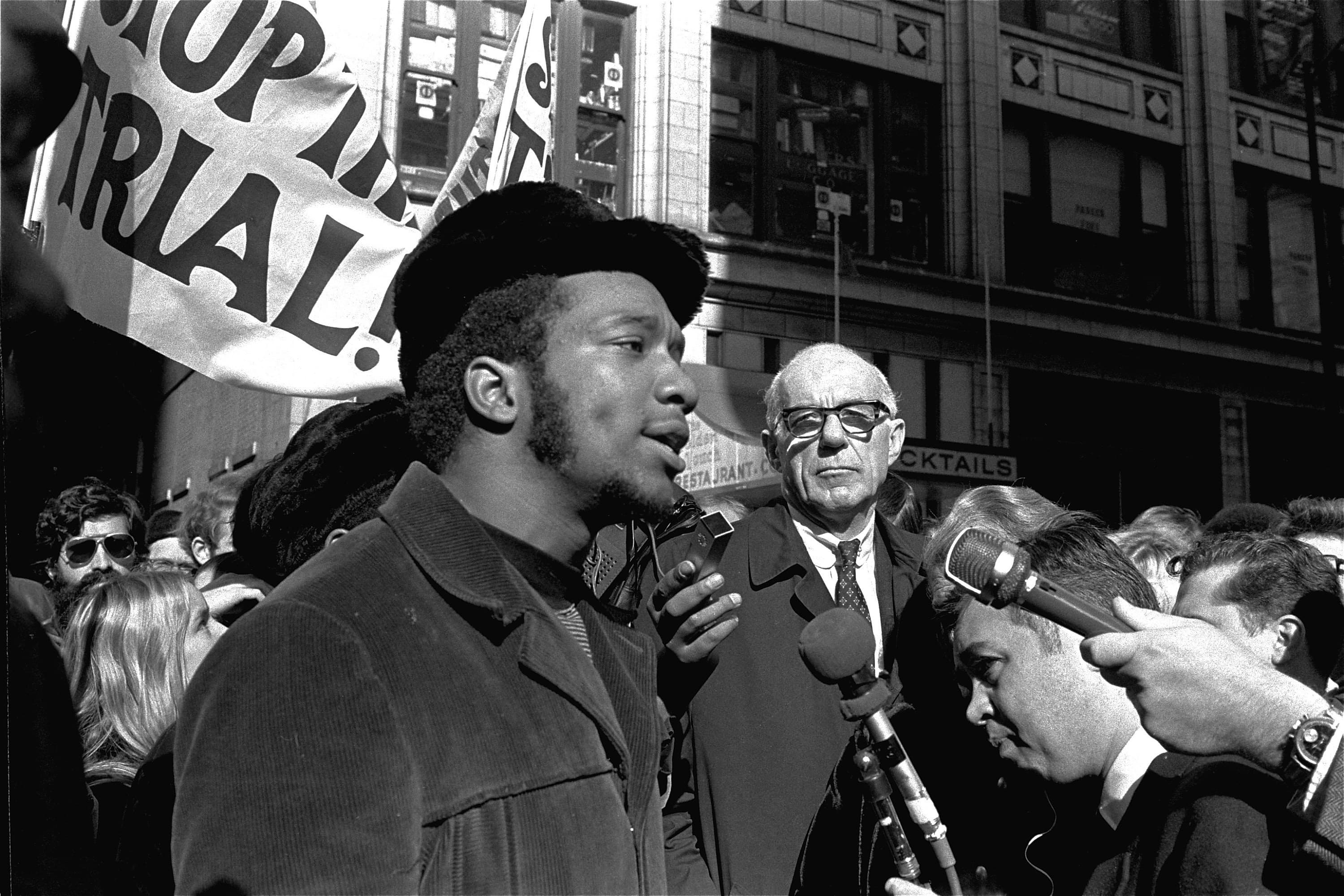 In this Oct. 29, 1969, file photo, Fred Hampton, center, chairman of the Illinois Black Panther party, speaks outside a rally outside the U.S. Courthouse in Chicago while Dr. Benjamin Spock, background, listens. (AP Photo/ESK, File)