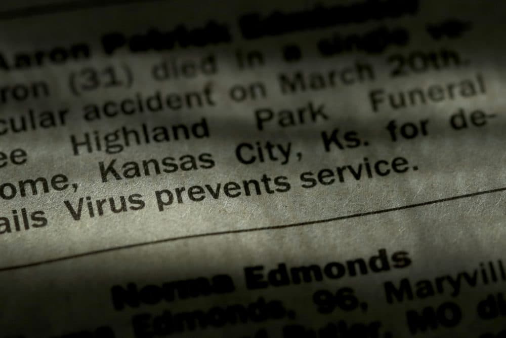 An obituary in the Kansas City Star newspaper details the effect of the COVID-19 pandemic on traditional funeral services, Sunday, April 5, 2020, in Overland Park, Kan. Most funerals now are either small private services with a public memorial service sometime in the distant future or no public service at all in response to social distancing and stay-at-home orders implemented in an effort to stem the spread of the new coronavirus. (Charlie Riedel/AP)