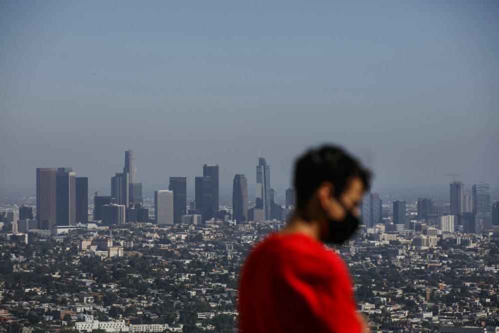 Izzy Galvan, 20, wears a face mask while visiting the Griffith Observatory overlooking downtown Los Angeles, Wednesday, July 15, 2020, in Los Angeles. (AP Photo/Jae C. Hong)