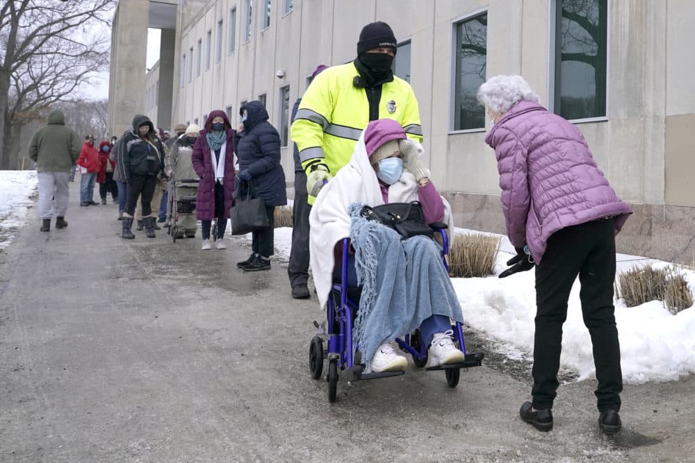 People wait in line for a coronavirus vaccine in Wakefield Monday as the snowstorm begins. (Elise Amendola/AP)