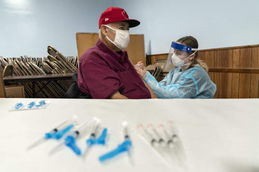 Mario Valdez, 62, receives his first shot of a vaccine at a clinic in Central Falls, Jan. 9, 2021. &quot;I feel happy,&quot; the 62-year-old school bus driver said. (David Goldman/AP)