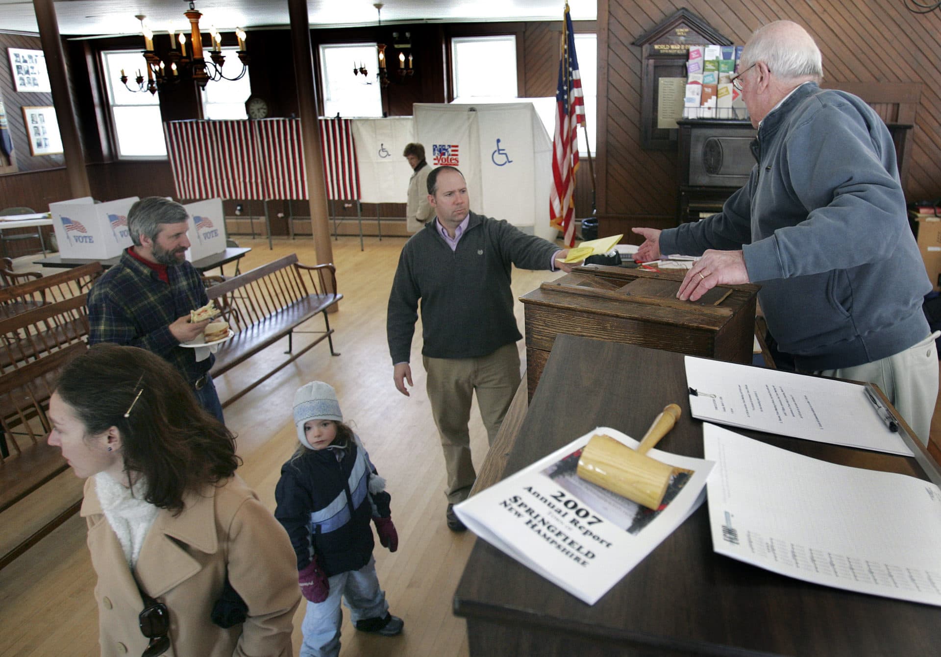 In this March 11, 2008, file photo, moderator Dick Kipperman, right, accepts a resident's ballot during the annual town meeting in Springfield, N.H. (Jim Cole/AP File)