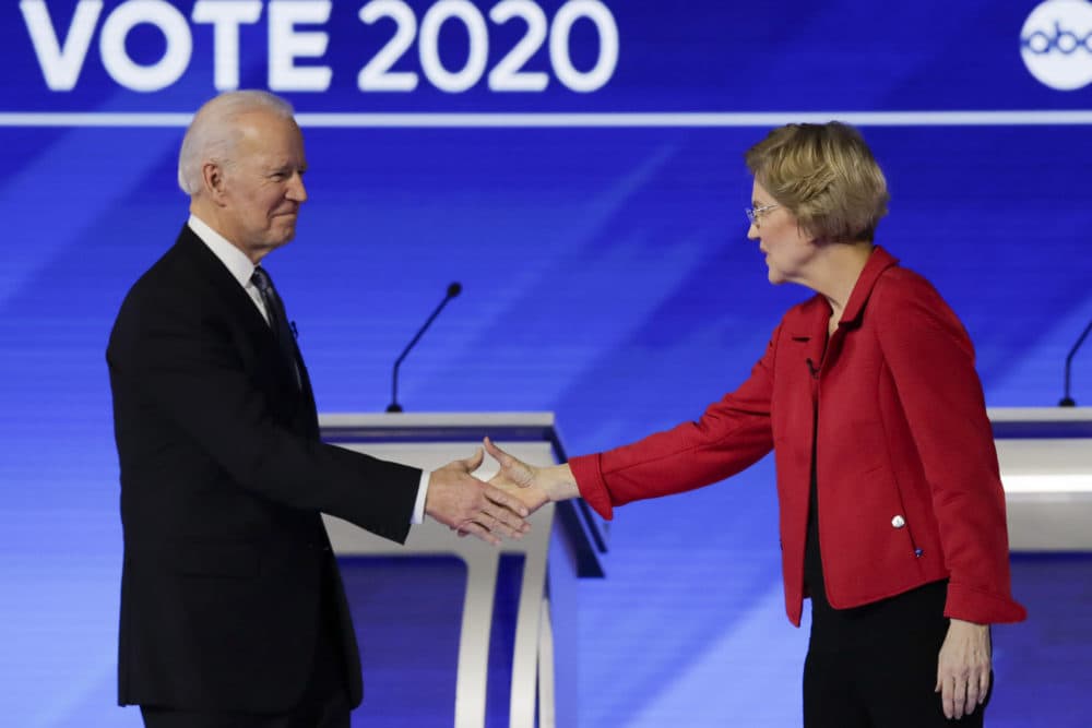 In this Feb. 7, 2020 file photo, Joe Biden and Elizabeth Warren shake hands on stage before the start of a Democratic presidential primary debate. (Charles Krupa/AP)