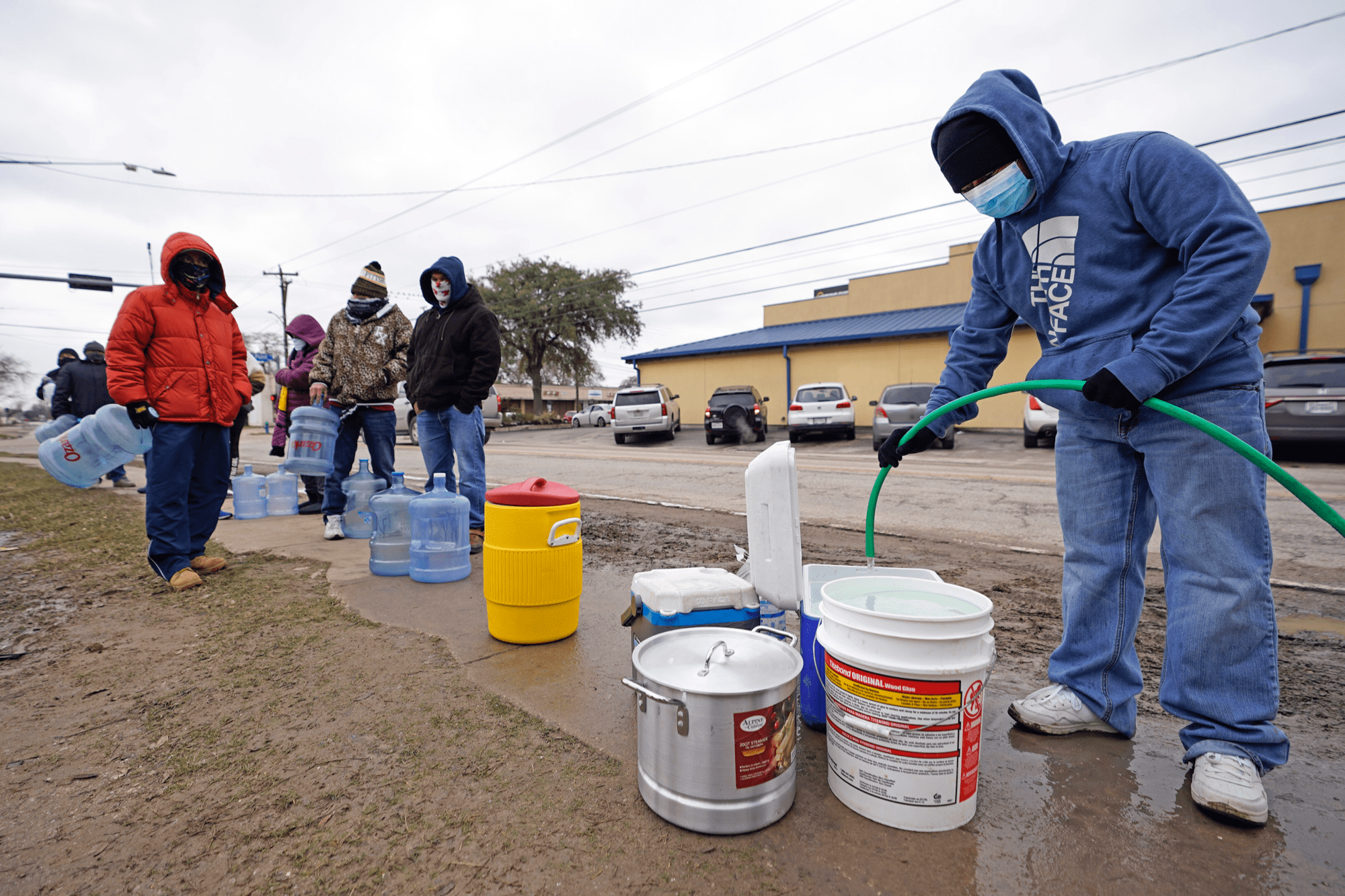 A man fills a cooler with water from using a hose from a public park spigot Thursday, Feb. 18, 2021, in Houston. (David J. Phillip/AP)
