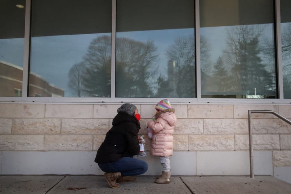 Preschool teacher Johari Pimentel helps her daughter collect a specimen upon arriving at Temple Beth Shalom in Needham, MA on January 21, 2021. (Craig F. Walker/The Boston Globe via Getty Images)