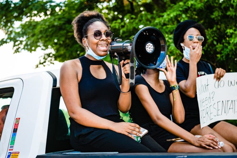 Doralee Heurtelou rallies the crowd in Arlington during a Black Lives Matter protest she helped organize in June with other Black high school alumni. (Kristin Chalmers for WBUR)