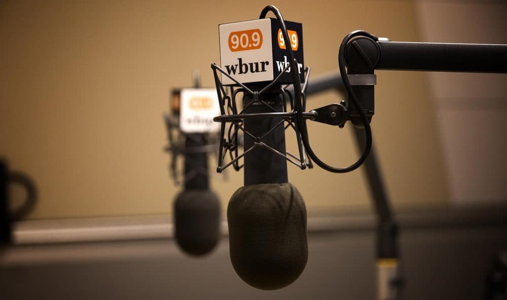 Microphones show the WBUR logo in a studio