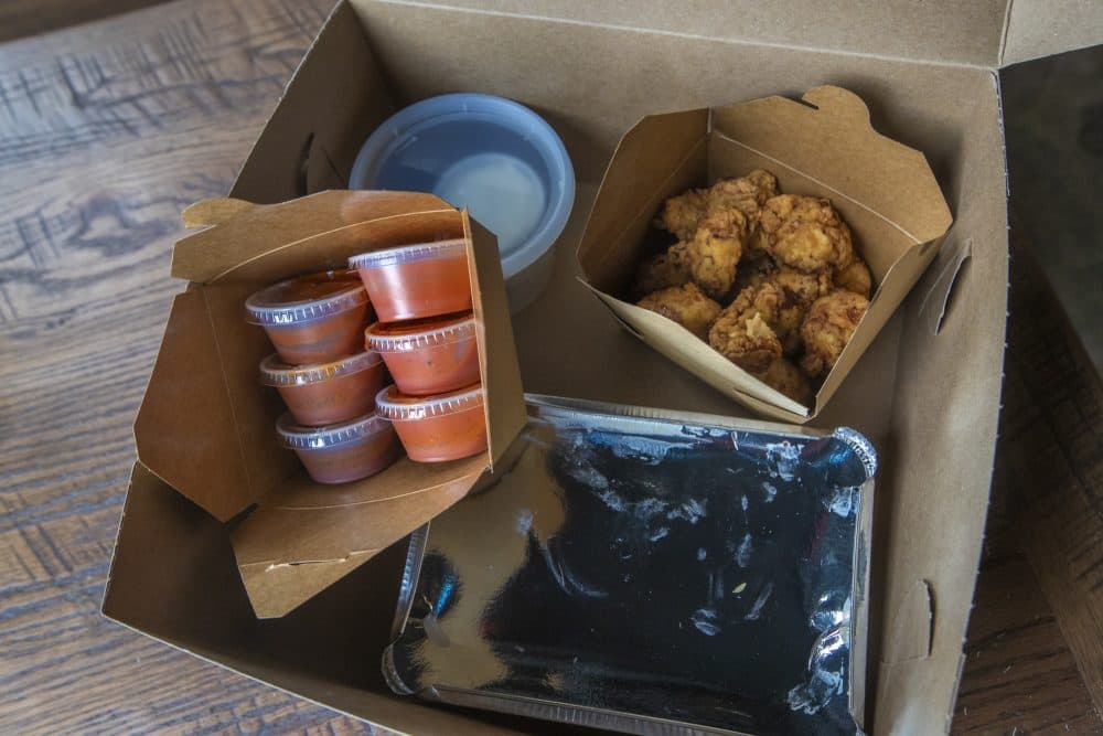 The contents of the &quot;Hell Night&quot; food box. This one contains chicken tenders, rice, six incrementally hot sauces and dill pickle ranch dressing. (Jesse Costa/WBUR)