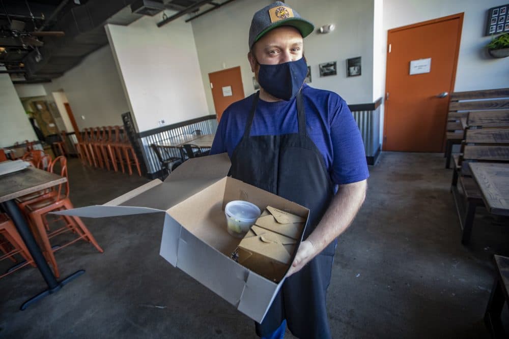 Brato co-founder and executive chef Jonathan Gilman holds a &quot;Hell Night&quot; food box. (Jesse Costa/WBUR)