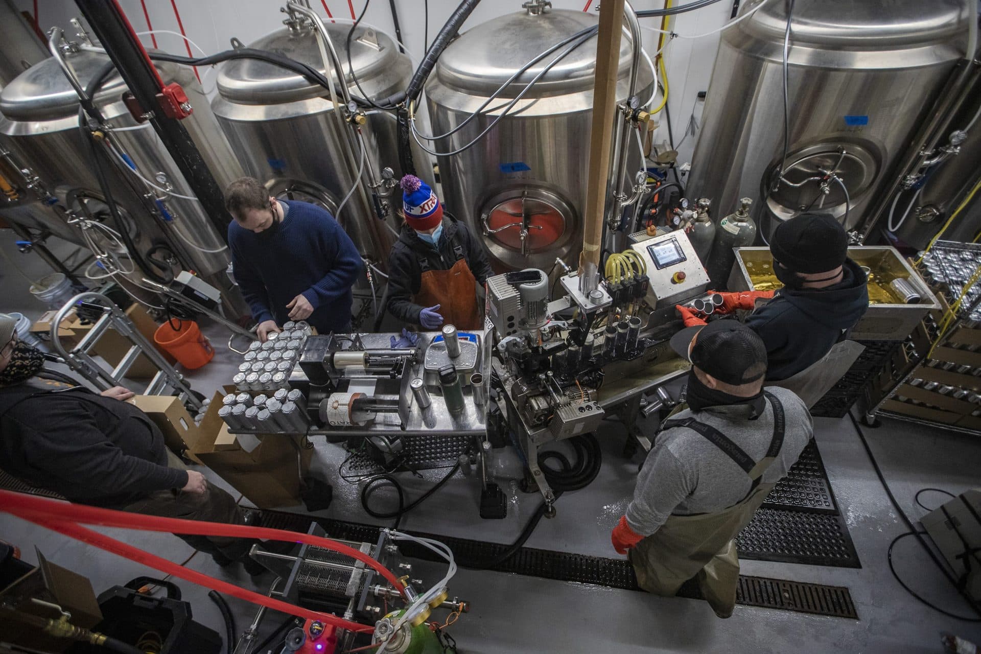 Mobile canners State 64 cans Brato Brewhouse’s N. Beacon Light Helles Lager in a tight space inside the brewery. (Jesse Costa/WBUR)