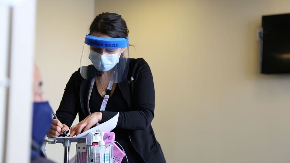 Natasha Viveiros, RN, works to vaccinate a patient at the Chafee Health Center in Providence. (Brett Davey/Providence Community Health Centers via RIPR)