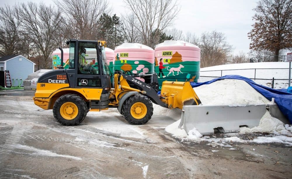 A front end loader picks up solar salt to put into the brine mixer at the Cambridge Public Works yard at Danehy Park. (Robin Lubbock/WBUR)