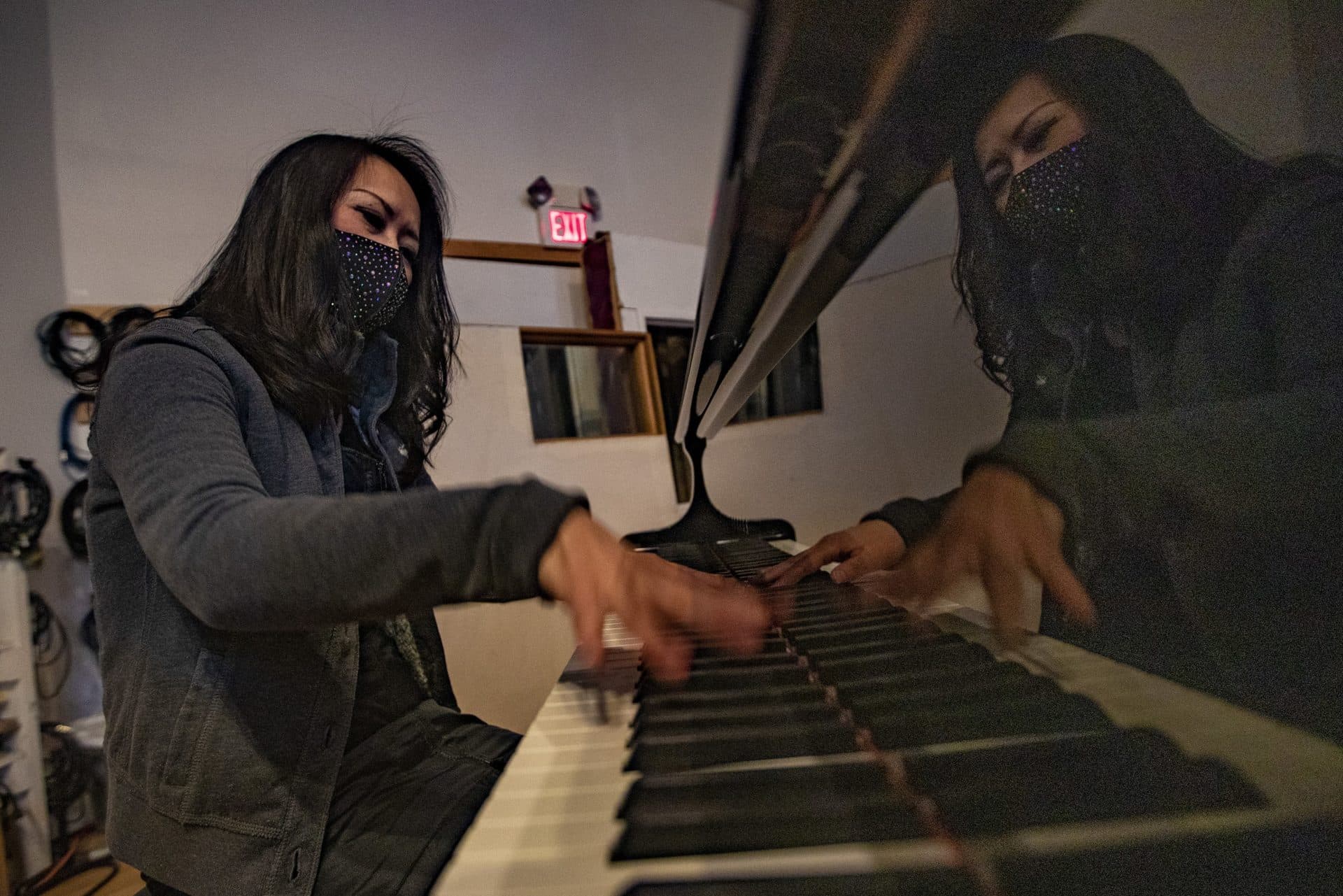 Pianist Yoko Miwa warms up before a recording session after Fred Mudge has tuned the piano at the Wellspring Studio. (Jesse Costa/WBUR)