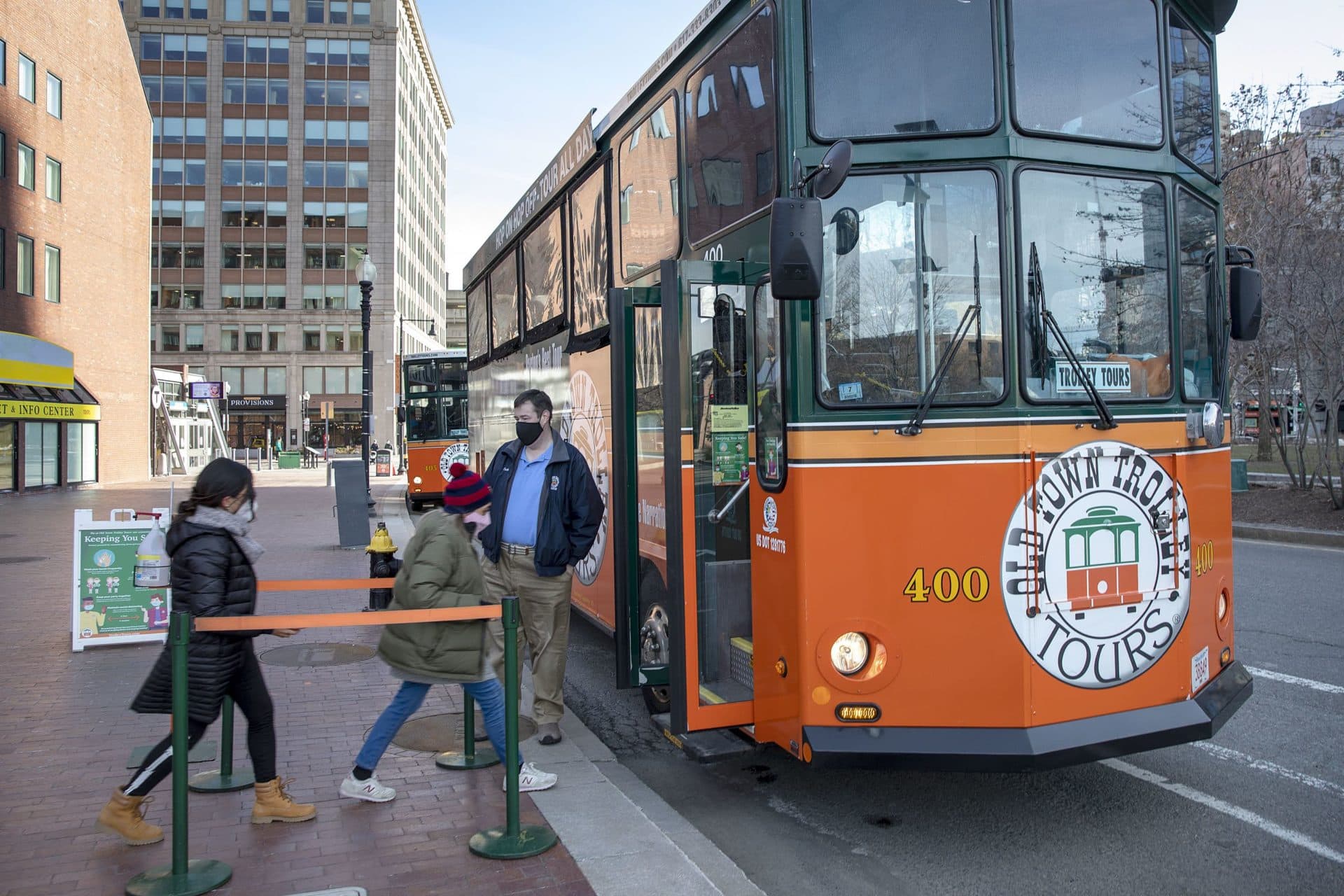 Driver Micheal Long welcomes a couple visitors into his trolley tour. (Robin Lubbock/WBUR)