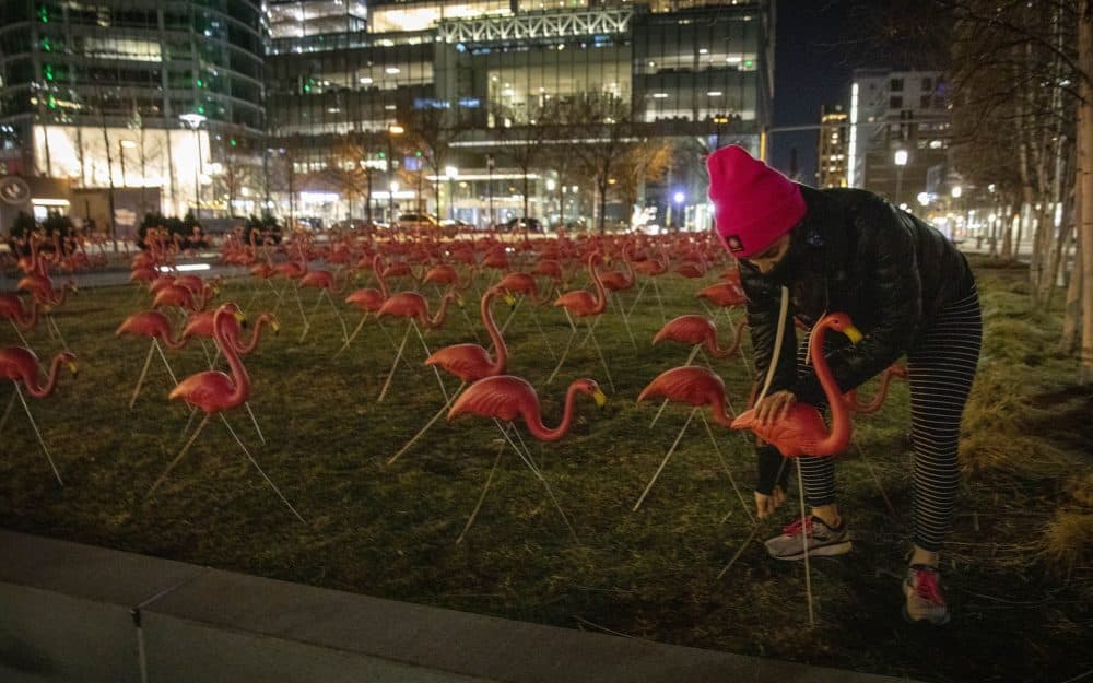 Emily Soukas, senior manager of activations and partnerships at WS Development, Boston Seaport, helps setting up flamingos at Seaport Common. (Robin Lubbock/WBUR)