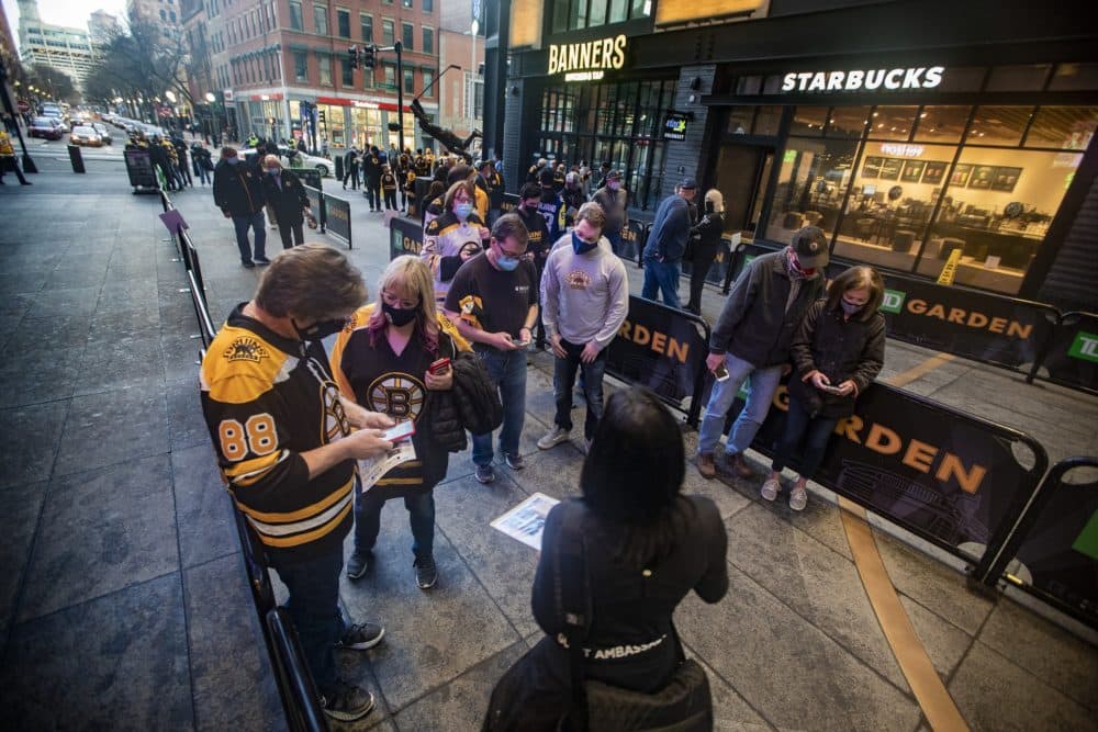 TD Garden staff assist Bruins fans to answer questions on the “Promise to Play it Safe” app to assure each fan has complied with certain health protocols prior to entering the building. (Jesse Costa/WBUR)