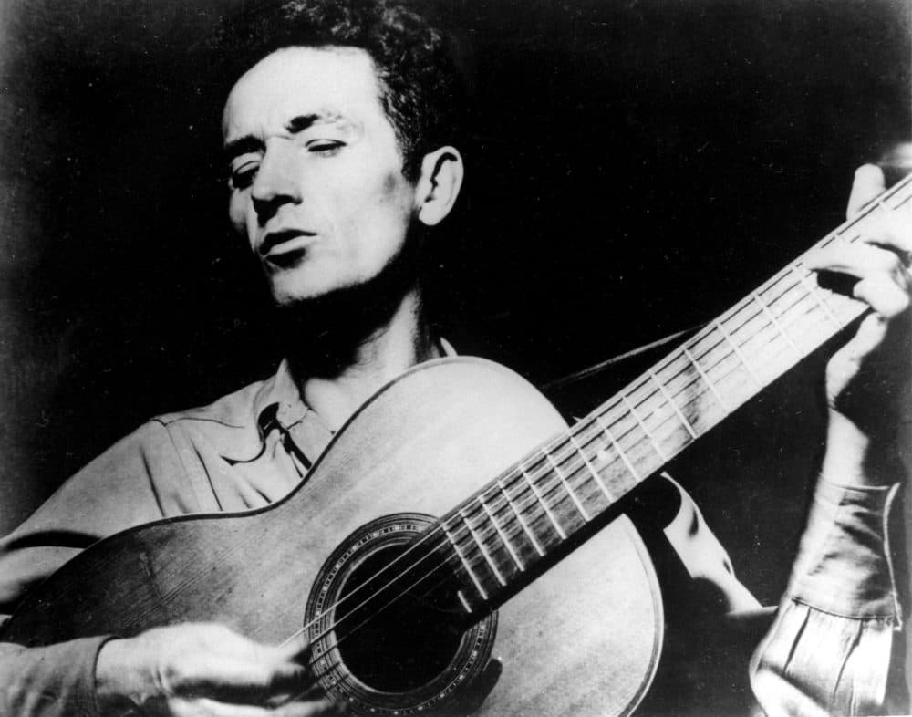 Folk singer Woody Guthrie plays his guitar. (AP Photo)