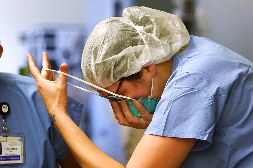 On Tuesday, Jan. 26, 2021, registered nurse Diane Miller pulls on an N-95 mask as she enters the "red zone" before heading into a patient's room in the COVID Acute Care Unit at UW Medical Center in Montlake in Seattle. (Elaine Thompson/AP)