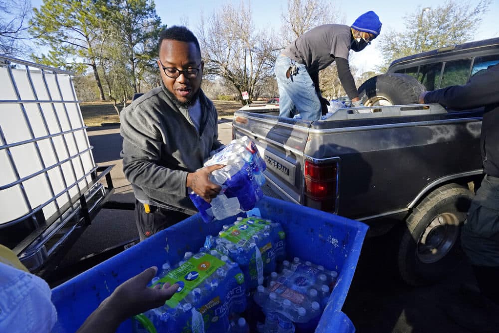 Madonna Manor maintenance supervisor Lamar Jackson left, stacks bottled water brought by Mac Epps of Mississippi Move, as part of the supply efforts by city councilman and State Rep. De'Keither Stamps to a senior residence in west Jackson, Miss. (Rogelio V. Solis/AP Photo)